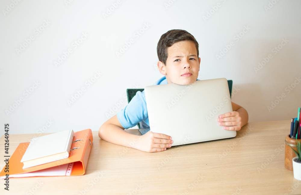 Young boy smiling and watching laptop in the classroom.A young boy student typing computer for learning online at his home. Young boy smiling and watching laptop in the classroom.A young boy student typing computer for learning online at his home.