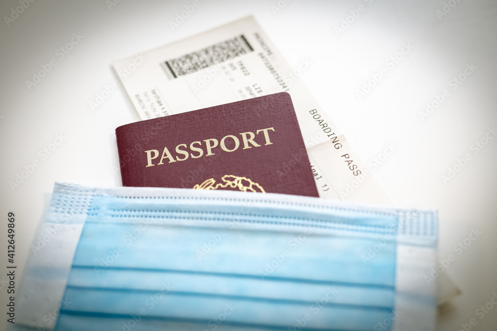 Close up of passport, boarding pass and medical mask. Ready to departure for a trip during Coronavirus pandemic. Closure of airports restricted traveling. New rules. Business travel health concept. Close up of passport, boarding pass and medical mask. Ready to departure for a trip during Coronavirus pandemic. Closure of airports restricted traveling. New rules. Business travel health concept.