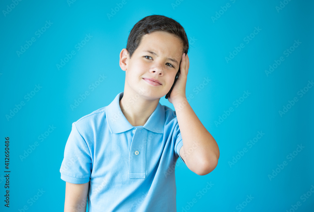 Young caucasian boy with phone isolated over blue background Young caucasian boy with phone isolated over blue background