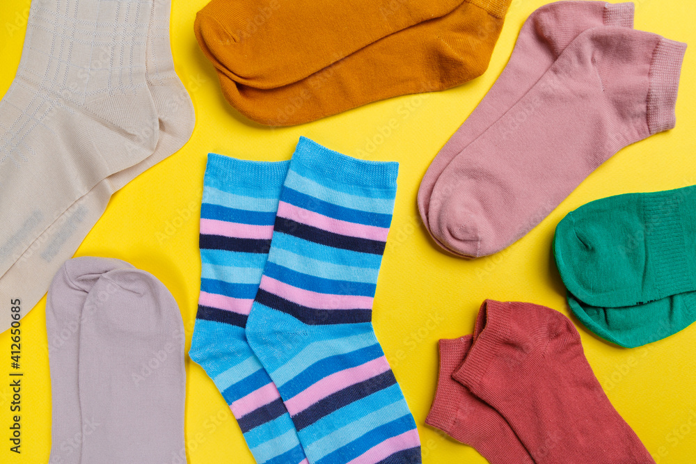 View from above. Socks are scattered on a yellow background. Clothing in the form of socks. View from above. Socks are scattered on a yellow background. Clothing in the form of socks.