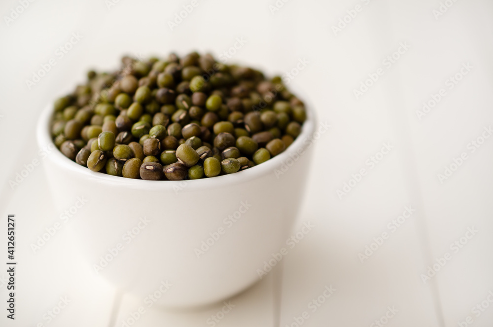 Mung beans in a white bowl on white backdrop. Mung beans in a white bowl on white backdrop.