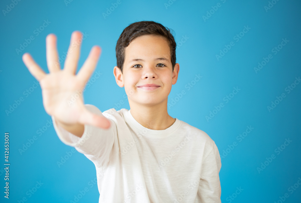 cool young boy smiling showing number five isolated on blue background cool young boy smiling showing number five isolated on blue background