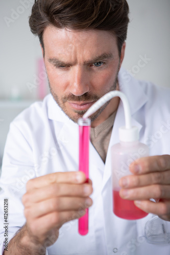 male scientist examining test tube
