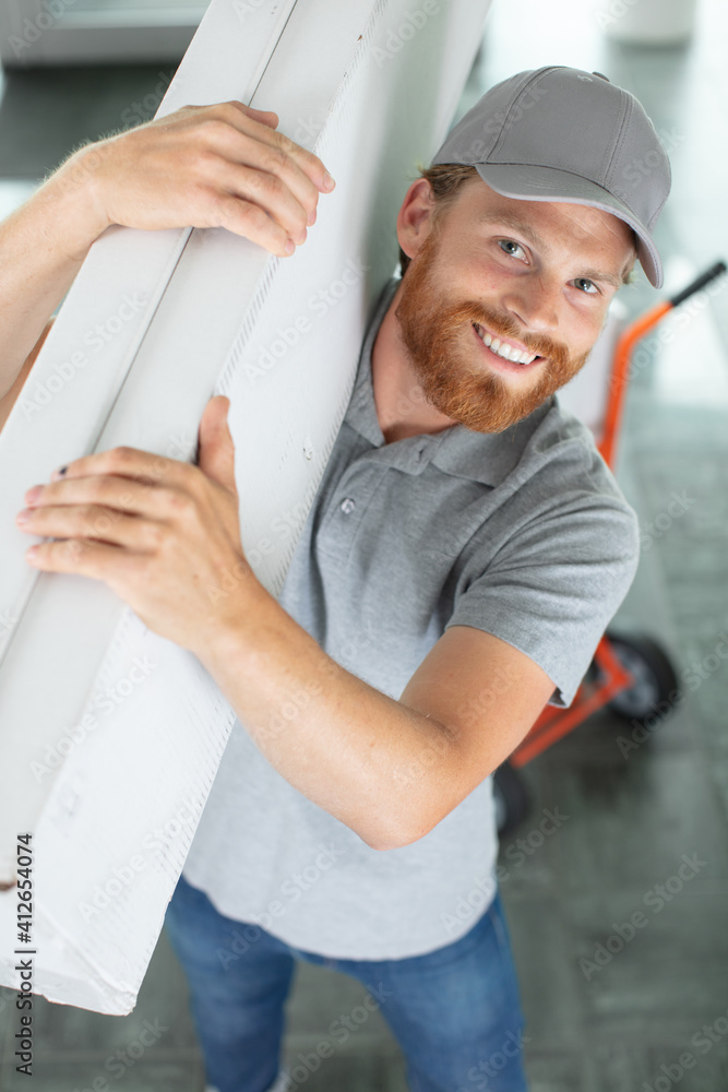 carpenter holding planks in a new house carpenter holding planks in a new house