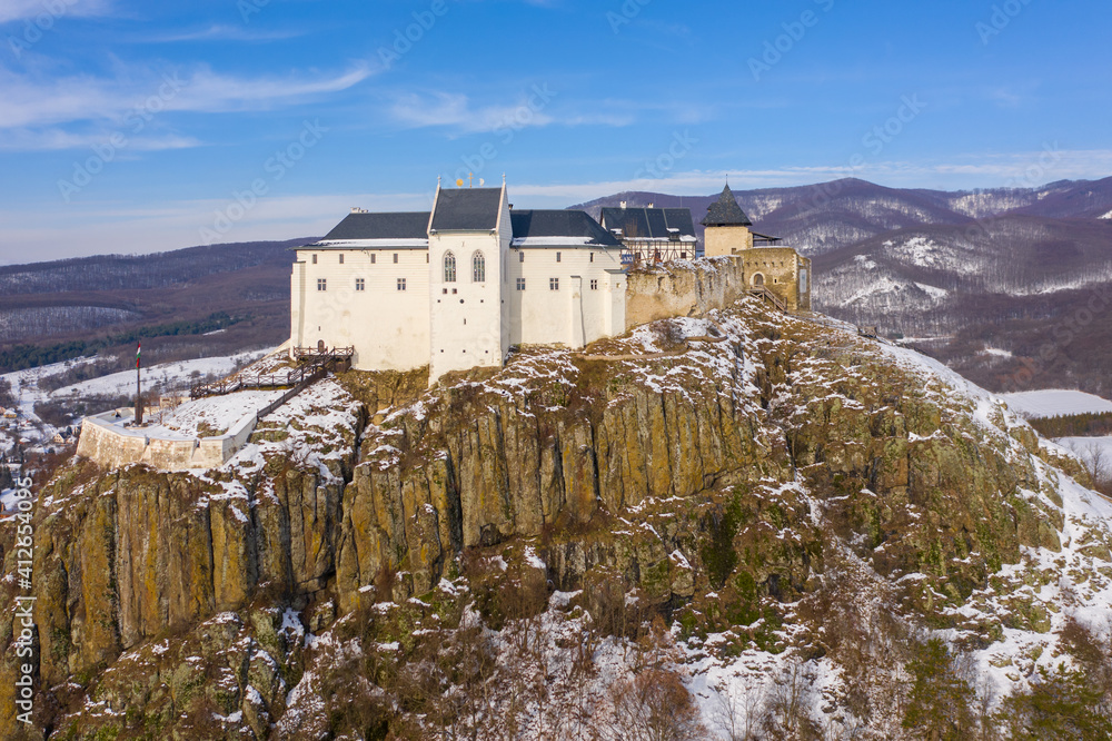 Füzér, Hungary - Aerial view of the famous castle of Fuzer built on a volcanic hill named Nagy-Milic. Zemplen mountains at the background. Winter landscape. Hungarian name is Füzér vára.