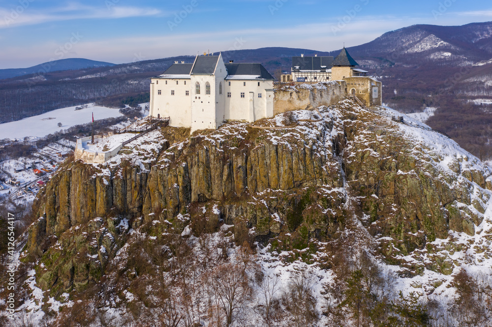Füzér, Hungary - Aerial view of the famous castle of Fuzer built on a volcanic hill named Nagy-Milic. Zemplen mountains at the background. Winter landscape. Hungarian name is Füzér vára.