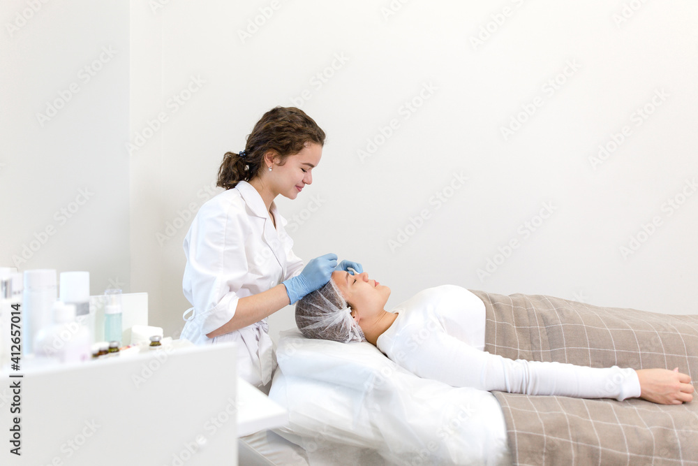 Obraz premium Cosmetologist doing a facial massage for a patient