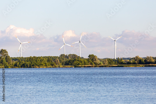 Wind turbines, renewable energy power plant near a lake in Poland