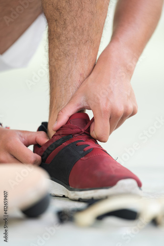 sportsman tucking lace inside his trainers
