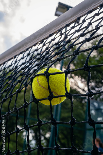 green tennis or paddle ball and court net with selected focus at high speed © patoouupato