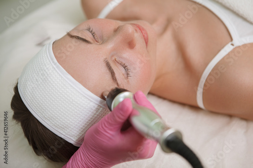 Close up of a woman getting skin tightening facial treatment at cosmetology clinic