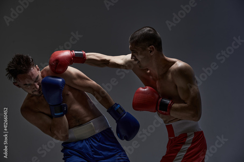 Jab of professional fighter, fighting guys in boxing gloves during mixed fight sparring, martial arts concept © Georgii