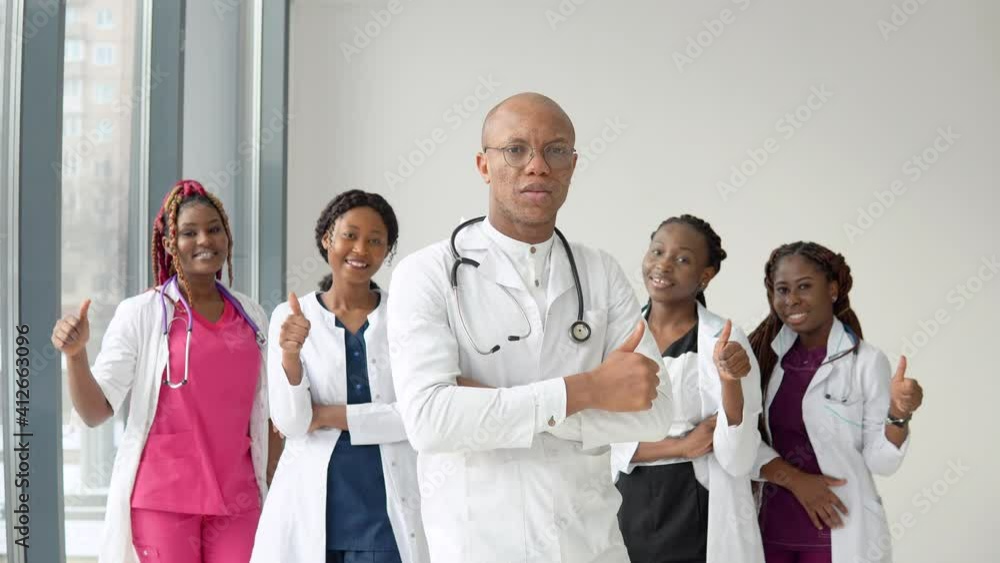 An African American doctor and nurse stand in front of the camera and look straight ahead An African American doctor and nurse stand in front of the camera and look straight ahead