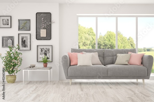 White living room with sofa and summer landscape in window. Scandinavian interior design. 3D illustration © AntonSh