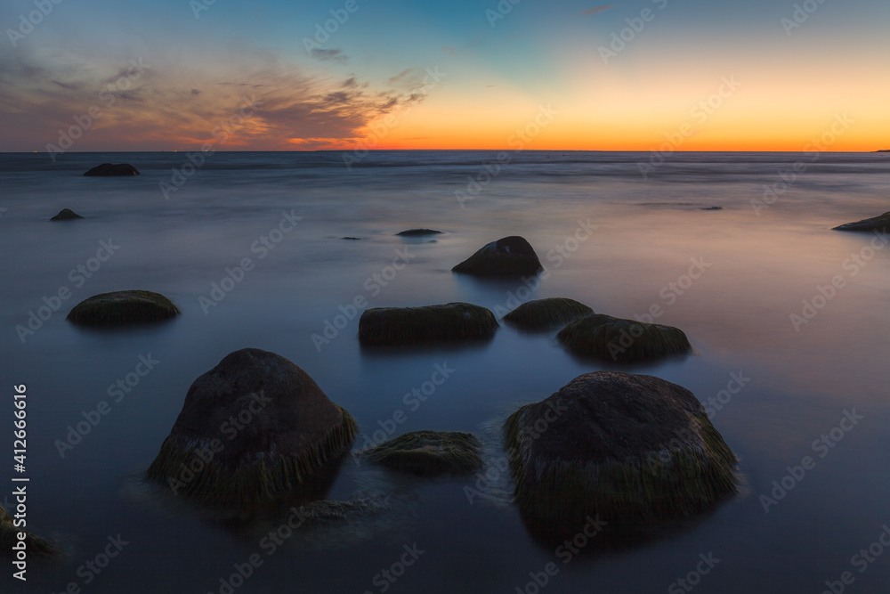 Beautiful colorful sunset over sea and boulders. Baltic sea shore, Estonia. Beautiful colorful sunset over sea and boulders. Baltic sea shore, Estonia.