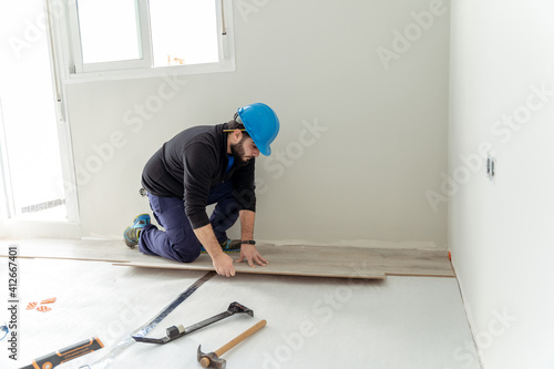 Man worker assembling laminate flooring.