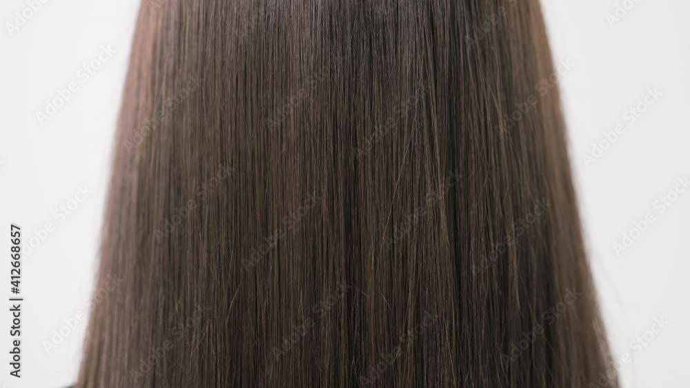 Demonstration of smooth and silky brunette hair after straightening it with a steampod. High quality 4k footage. Close-up Demonstration of smooth and silky brunette hair after straightening it with a steampod. High quality 4k footage. Close-up