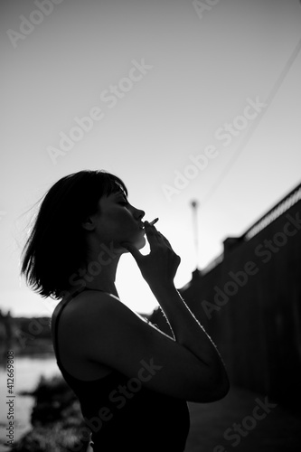 monochrome silhouette of a girl with a cigarette photo