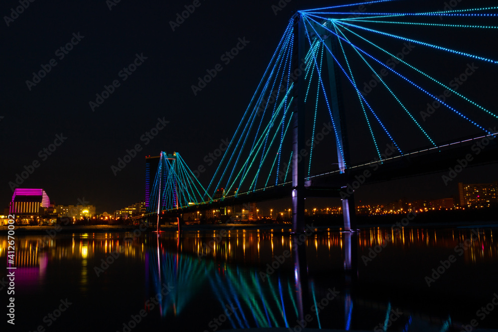 Night cityscape of bridge over Yenisei river in Krasnoyarsk, Russia. Background for postcards, placard, advertising with copy space
