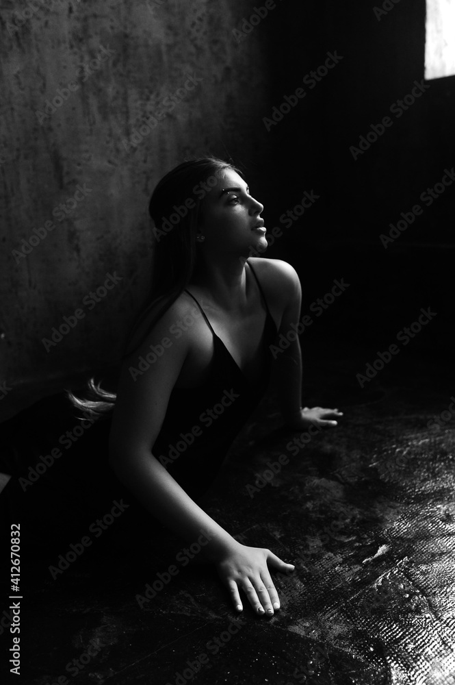 Beautiful woman with long luxurious shiny hair in dark dress in loft room. Beautiful woman with long luxurious shiny hair in dark dress in loft room.