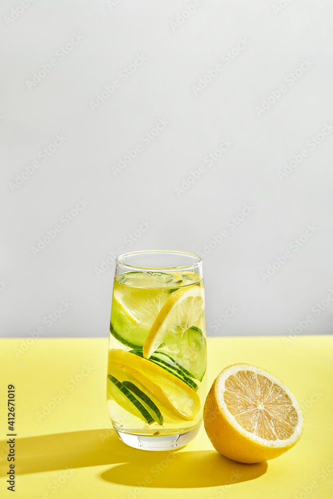 Fototapeta premium glass of cool homemade lemonade on a yellow background with space for text