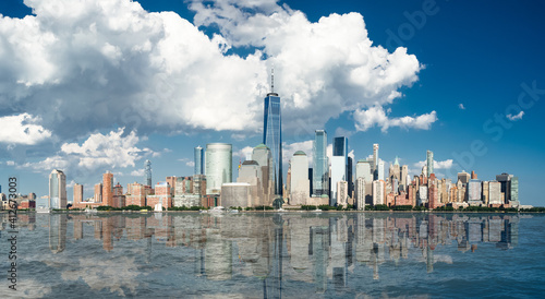 Beautiful panorama on Manhattan skyline. Centered on the tallest building with scenic clouds at the background.