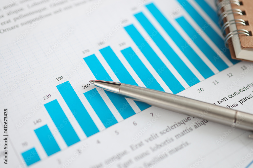 Metal ballpoint pen lying on documents with graphs closeup Metal ballpoint pen lying on documents with graphs closeup