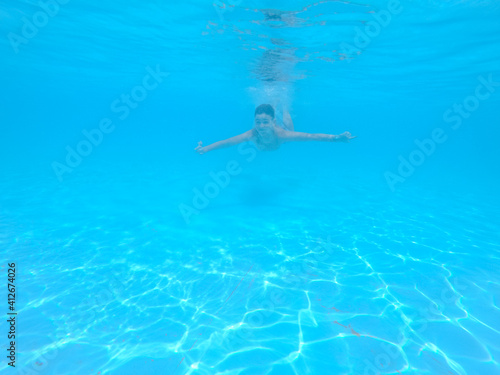 boy swimming in pool with blue water in vacation