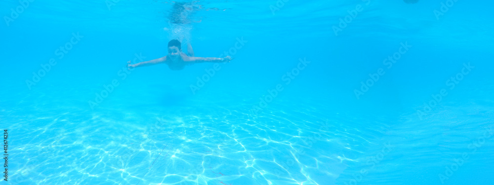 boy swimming in pool with blue water in vacation boy swimming in pool with blue water in vacation