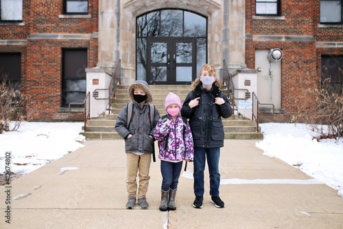 Little Kids Sitting on Steps to School Building with Protective Covid Masks