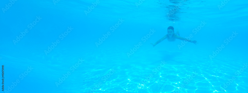 boy swimming in pool with blue water in vacation