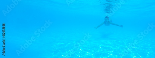 Obraz na płótnie boy swimming in pool with blue water in vacation w salonie