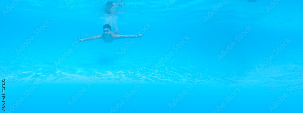 boy swimming in pool with blue water in vacation boy swimming in pool with blue water in vacation