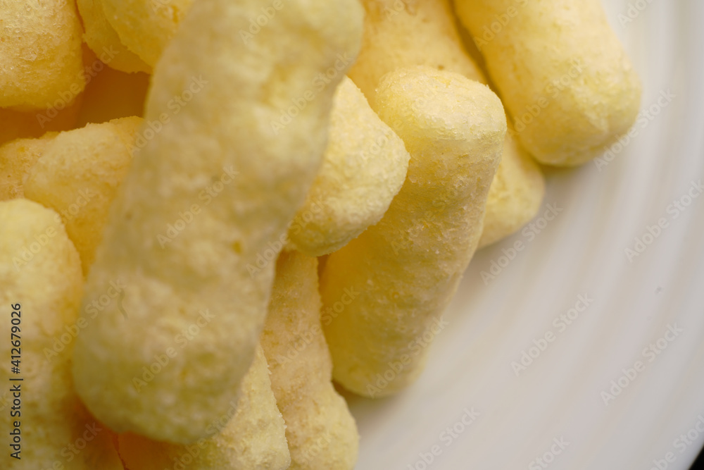 Corn sweet sticks very close on a white plate. Golden color.
