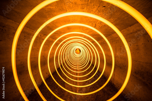 Long exposure, light painted yellow spiral in tunnel