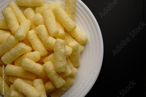 Corn sweet sticks on a white plate top view. Golden color. photo