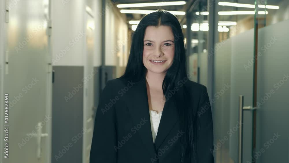 Portrait of a successful businesswoman with glasses looking into the camera of European appearance. He is standing in the corridor and holding a tablet. A professional works on a touch device Portrait of a successful businesswoman with glasses looking into the camera of European appearance. He is standing in the corridor and holding a tablet. A professional works on a touch device