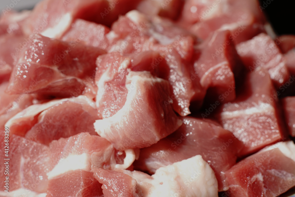 Raw pieces of red pork meat closeup. Finely chopped for cooking. Raw pieces of red pork meat closeup. Finely chopped for cooking.