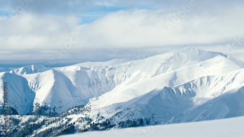 Winter mountain landscape. Clouds drifting above snowy peaks. High quality photo © CameraCraft