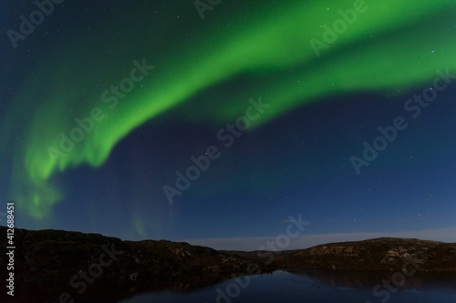 Beautiful northern lights in winter over the tunra and hills. © Moroshka