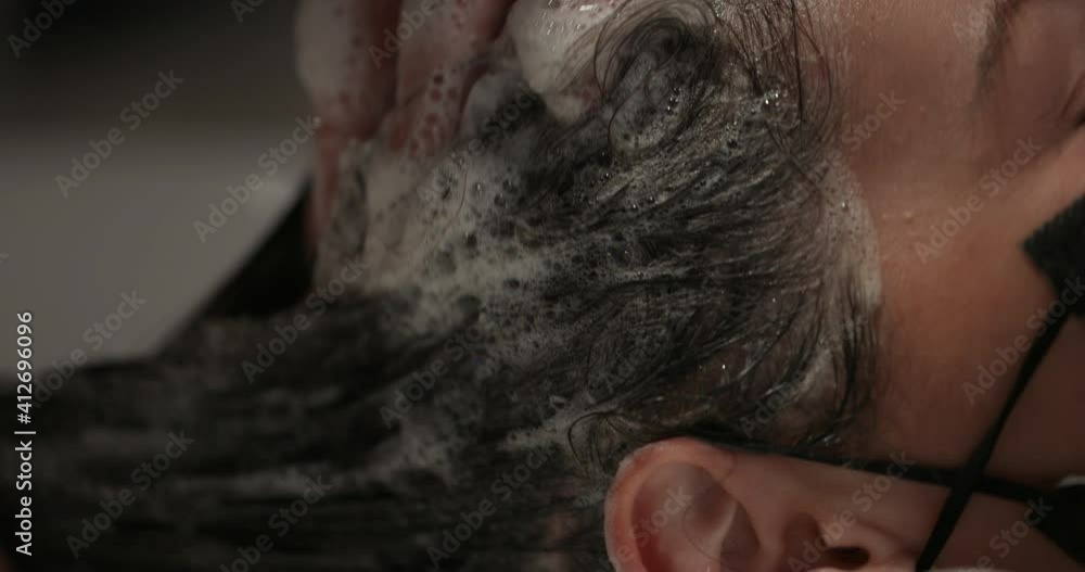 Extreme close up of shampoo being applied to clients hair during covid - shampoo suds Extreme close up of shampoo being applied to clients hair during covid - shampoo suds