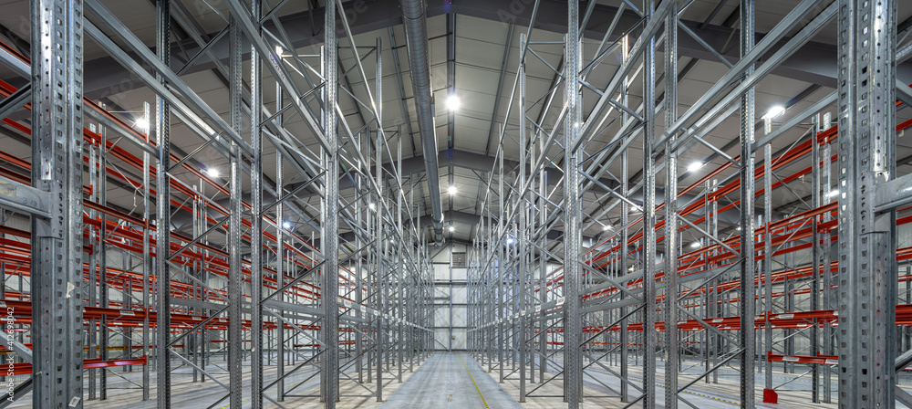 Interior of huge empty storehouse. Industrial warehouse racking.