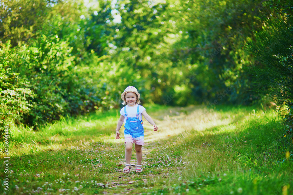 Adorable toddler girl having fun outdoors on a sunny summer day Adorable toddler girl having fun outdoors on a sunny summer day