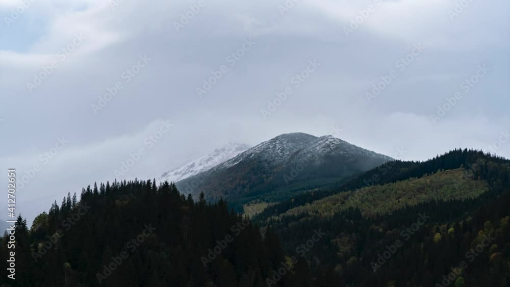 The snow-covered peak of the mountain is overgrown with a pine forest. Timelapse of the Carpathian landscape. The snow-covered peak of the mountain is overgrown with a pine forest. Timelapse of the Carpathian landscape.