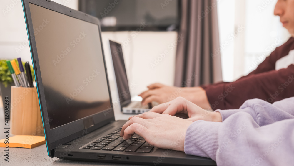 Unrecognizable man and woman using laptops while working remote from home. Unrecognizable man and woman using laptops while working remote from home.