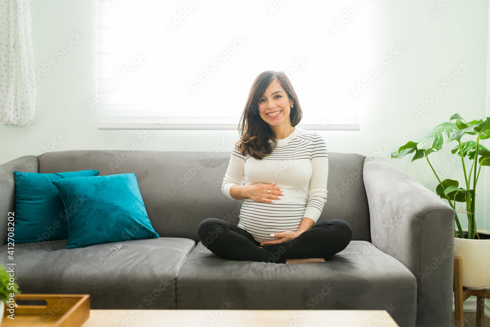 Portrait of a beaming pregnant woman caressing her belly Portrait of a beaming pregnant woman caressing her belly