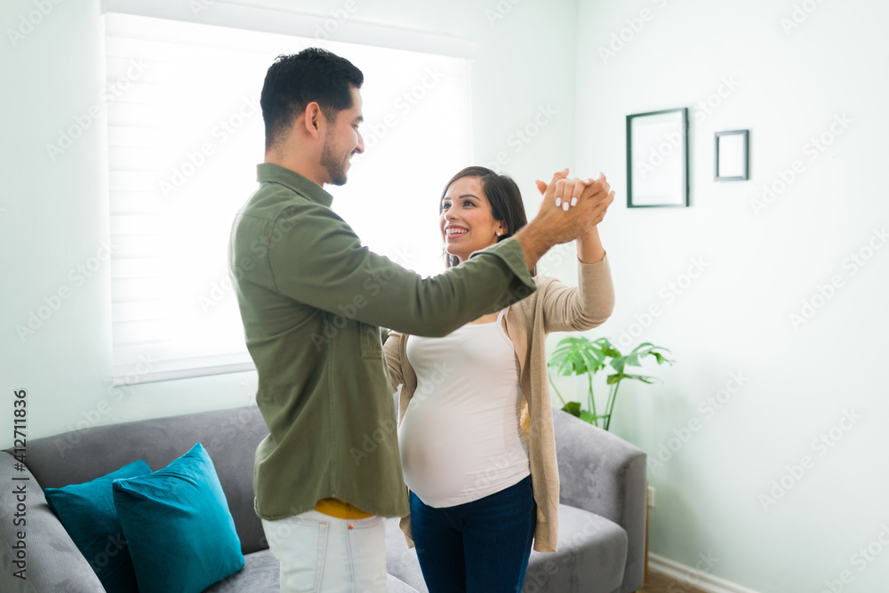 Obraz premium Happy husband and wife listening to music and dancing in the living room