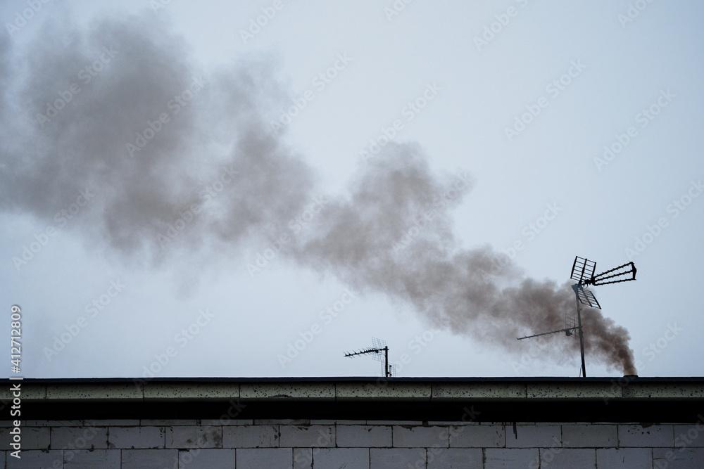 Steaming chimney with antenna on the roof. Steaming chimney with antenna on the roof.