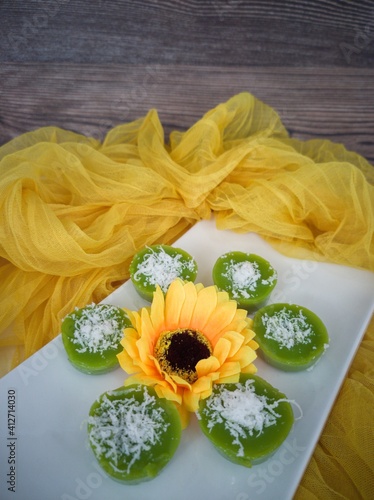 Steamed Pandan Rice Cake or locally known as Kuih Lompang or Kuih Kasui  with desiccated coconut on top. Selective focus points. Blurred background