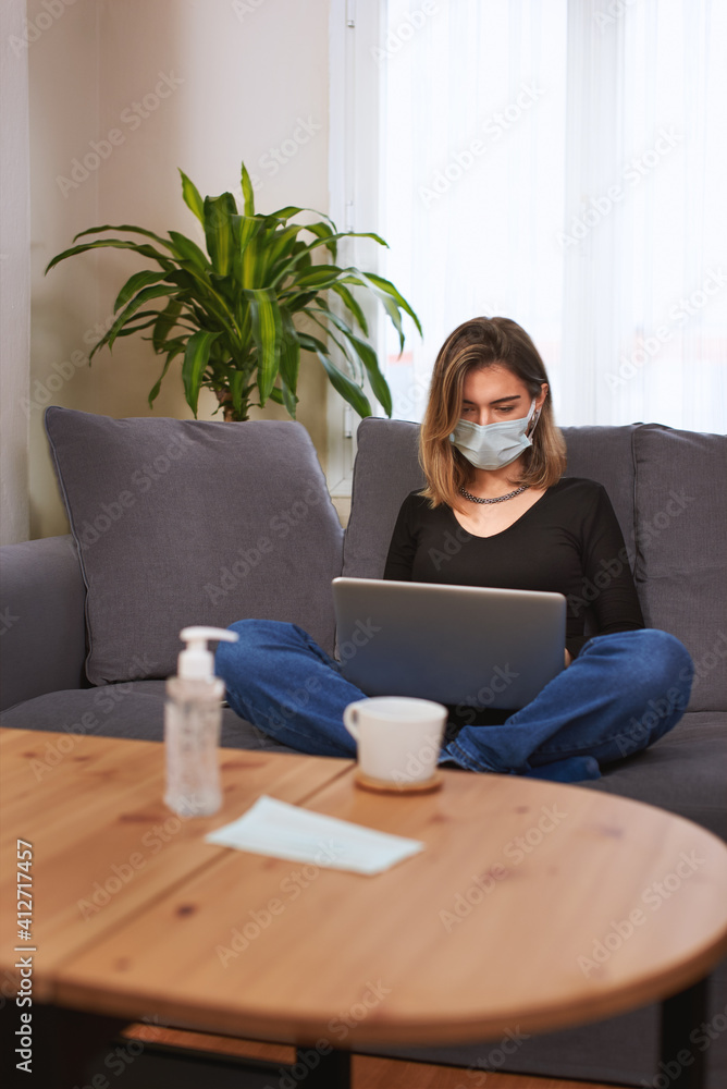 Caucasian white Teenager girl working on her laptop computer while sitting cross legged on the couch. Caucasian white Teenager girl working on her laptop computer while sitting cross legged on the couch.